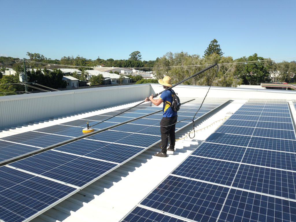 Crystal Clear Solar expert is cleaning the solar panel at the roof